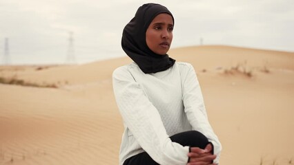 Wall Mural - Beautiful female runner wearing sport abaya running in the desert in dubai, united arab emirates. Concept about sport, and muslim culture