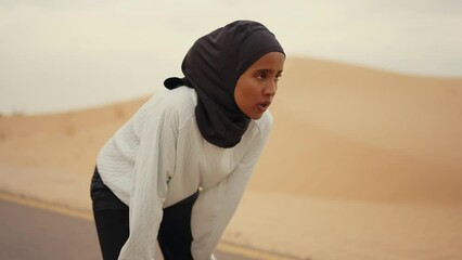 Wall Mural - Beautiful female runner wearing sport abaya running in the desert in dubai, united arab emirates. Concept about sport, and muslim culture