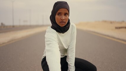 Wall Mural - Beautiful female runner wearing sport abaya running in the desert in dubai, united arab emirates. Concept about sport, and muslim culture