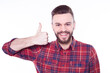 © My Ocean studio - Attractive cheerful young man wearing checkered shirt standing isolated over white background and showing thumb up