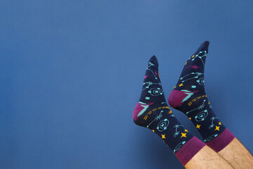 Wall Mural - Male legs in socks on blue background, space for text