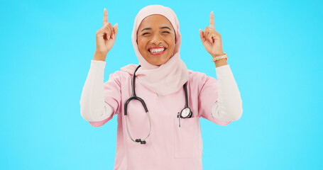 Sticker - Muslim nurse, happy woman and pointing finger portrait with space for healthcare, religion or happiness. Islamic female medical worker with hand, smile and hijab for announcement on blue background