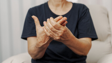 Close up hands of asian senior elderly woman with parkinson's disease symptom, hand numbness, finger lock, hand pain. Mental health and elderly care concept