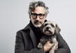 © TRINETTE + CHRIS - Serious studio portrait of mature styling man holding and cuddling his pet dog.  Generative AI.