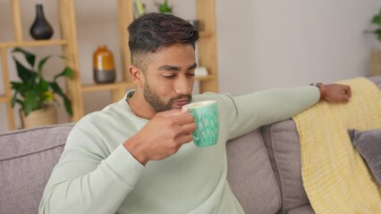 Poster - Relax, coffee and a man on a sofa in the living room of his home while remote working on a laptop. Happy, smile and break with a handsome young male drinking a beverage while sitting on the couch