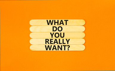 Wall Mural - What do you really want symbol. Concept words What do you really want on wooden stick. Beautiful orange table orange background. Business and what do you really want concept. Copy space.