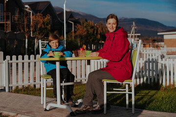 Sticker - Mother and son drink tea in the yard of a country house