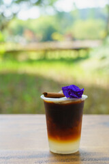 ice americano lemon coffee fresh drink for summer decorate with cinnamon and butterfly pea in plasti