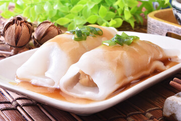 Wall Mural - Steamed rice rolls with fresh prawn filling served in a dish  on wooden table 