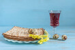 Red wine, matzah, quail eggs, celery sprig for Jewish holiday Pesach on blue wooden background.