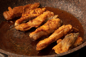 Wall Mural - The fish is fried in a frying pan in oil. Close-up.