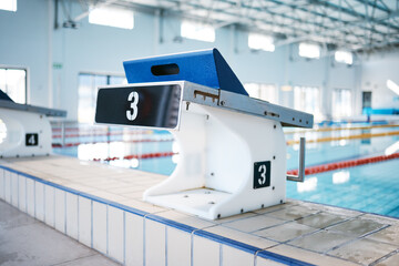 Canvas Print - Start, platform and water sports with block at swimming pool for championship, jumping and race. Fitness, competition and wellness with lane in indoor arena for exercise, workout and training