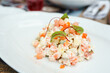 Olivier salad with salmon on a white plate