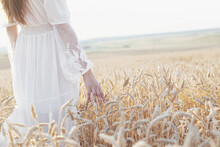 Beautiful Girl In White Dress Running On The Autumn Field Of Wheat At Sunset Time