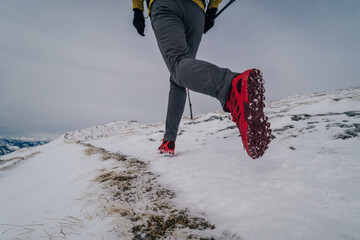 Wall Mural - Hiking or trail running in the mountains. Outdoor cross-country running in mountains in snow. Hiking, exercising, fitness and healthy lifestyle.