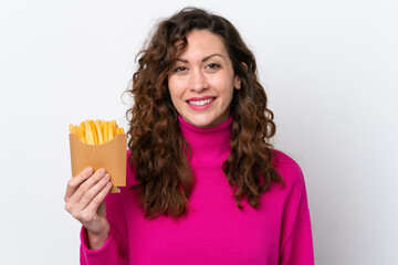 Canvas Print - Young caucasian woman catching french fries isolated on white background smiling a lot