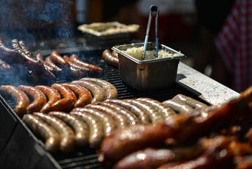 Sticker - a group of sausages cooking on the grill on top of a grill pan