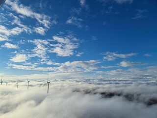 Sticker - Aerial view of a wind turbines seen obove the clouds under the blue sky