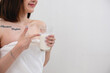 © PHAISITSAWAN - Portrait of young cheerful Asian woman drinking healthy milk on the morning of the holiday Good rest and healthy lifestyle concept.