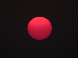 Wall Mural - red sun of sunset on black sky background