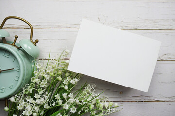 Sticker - Empty card mockup with flower bouquet and alarm clock on wooden background