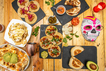 Wall Mural - Set of great Mexican food recipes with tacos al pastor, cochinita pibil tacos, nachos with guacamoles, quesadillas on wooden table
