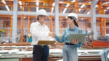Two Engineer Manager Leader And Woman Assistant Holding Laptop And Shaking Hands For Making Together After Processes Order At Metal Factory