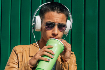 Wall Mural - teenager with headphones and drinking relaxed