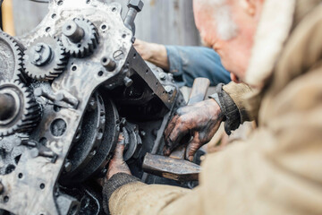 Wall Mural - tractor car engine repair at home, old man repairs the engine.