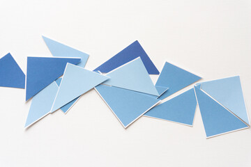 Wall Mural - blue triangles of various shapes scattered on blank paper