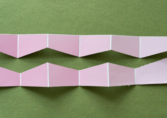 Wall Mural - two cut paper shapes (or pink paper stripe divided in two) on green