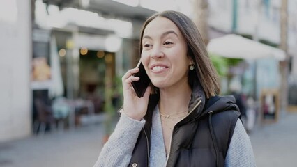 Canvas Print - Young beautiful hispanic woman smiling confident talking on smartphone at street