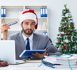 Wall Mural - Young businessman celebrating christmas in the office