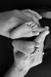 © Vad-Len - Black and white shade beautiful shape hands of mother, hold tiny newborn baby feet on black background with love, care, family safety and protection, child with premature birth concept or NICU care