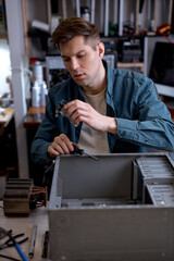 Wall Mural - professional technician man disassembles computer. Computer service and repair concept. pc computer disassembling in repair shop. Electronic development, electronic device fixing