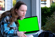 © Oleksandra - young pretty student woman bored tired over worked on her laptop wearing a black shirt isolated on green screen cromakey - chormakey or chroma croma key for composite. High quality photo