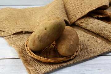 Wall Mural - fresh vegetable idaho or russet potato isolated in jute fiber background