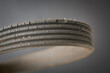 close-up of old used and worn out vehicle drive belt, isolated on gray background, failed and cracked serpentine belt with copy space, replaceable parts