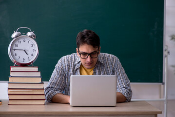 Wall Mural - Young male student in time management concept