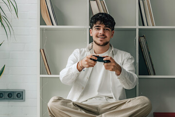 Wall Mural - young male at home with joystick playing video games