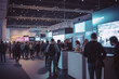Busy trade fair with a sea of booths and blurry business people