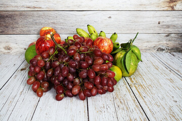 Wall Mural - Various of fruits with Red grape, red apple and green orange on wooden background