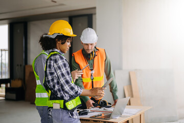 Engineer teams meeting working together wear worker helmets hardhat on construction site in city. industry professional team.