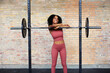 © Flamingo Images - Fit woman leaning on weights and smiling