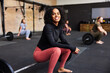 © Flamingo Images - Smiling woman sitting on weights in a gym