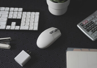 Poster - top view of office desk table with  calculator, notebook, plastic plant, mouse and keyboard.