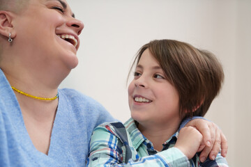 Happy Ukrainian family portrait. Short haired woman and little boy laughing in a cafe. Cheerful mother and elementary age son having fun together