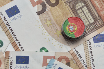 euro coin with national flag of portugal on the euro money banknotes background