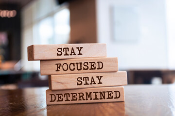 Wooden blocks with words 'Stay focused, stay determined'.