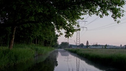 Canvas Print - Beautiful scenery of a creek reflecting the trees and the utility poles at dawn